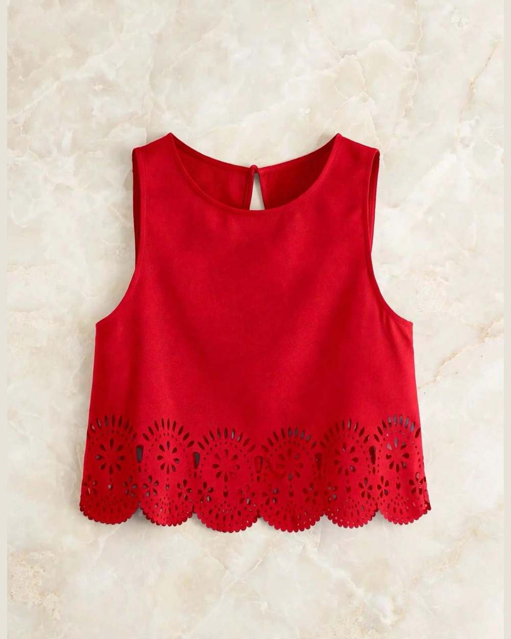 Blusa roja sin mangas con ruedo de encaje calado, aislada (gancho eliminado) sobre mármol marfil