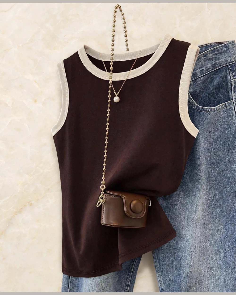 Blusa marrón sin mangas con ribete blanco en cuello y sisas