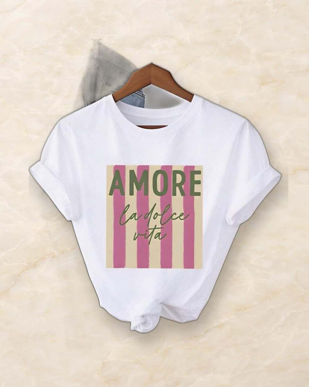 Franela blanca con estampado 'AMORE la dolce vita', aislada sobre mármol marfil