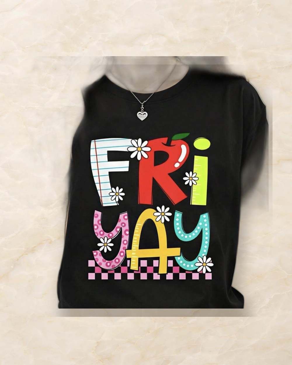 Franela negra con estampado 'FRI-YAY'., aislado sobre mármol marfil