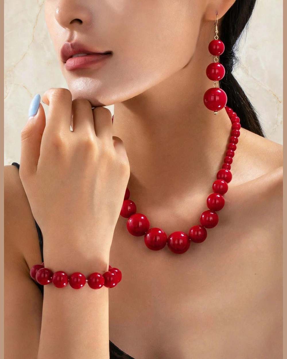 Modelo con set de collar, zarcillos y pulsera de perlas rojas